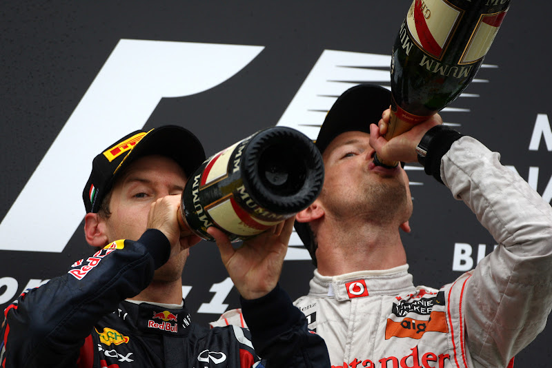 Себастьян Феттель и Дженсон Баттон пьют шампанское на подиуме Хунгароринга на Гран-при Венгрии 2011