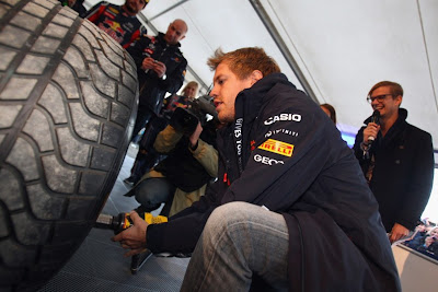 Себастьян Феттель закручивает колесо гайковертом на своем Red Bull в Хеппенхайме 20 октября 2011