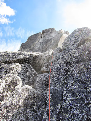 Heading up blocky terrain to the large ledge to move the belay into a better position for the final pitch to the top.