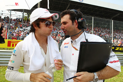 Серхио Перес с надутыми щеками слушает своего механика на Гран-при Италии 2011