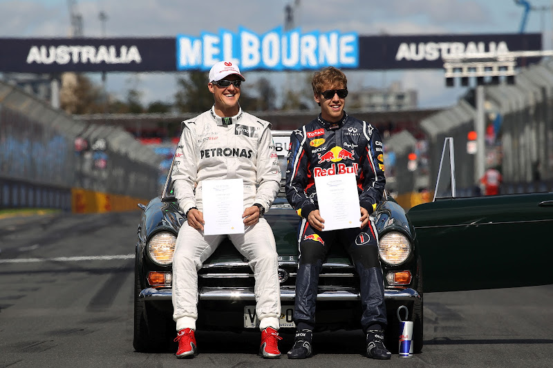 Михаэль Шумахер и Себастьян Феттель с бумажками FIA на фотосессии чемпионов на Гран-при Австралии 2012