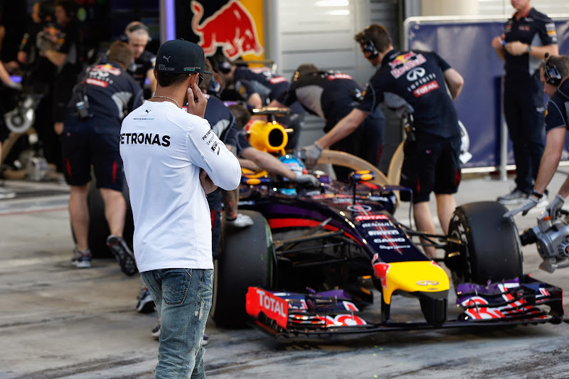 Льюис Хэмилтон следит за болидом Red Bull Себастьяна Феттеля на предсезонных тестах в Бахрейне 20 февряля 2014