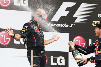 Эдриан Ньюи в очках и Себастьян Феттель с шампанским на подиуме Йонама на Гран-при Кореи 2012