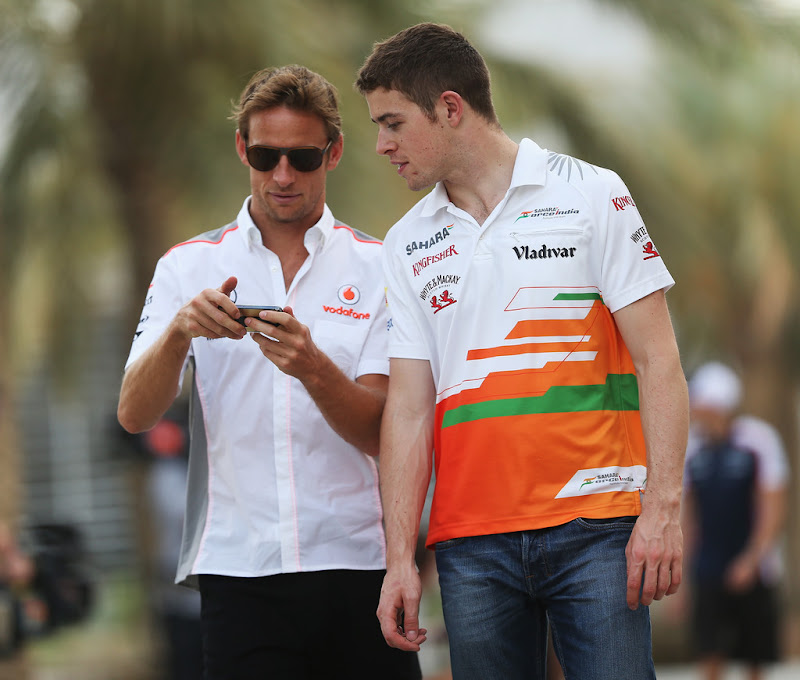 Дженсон Баттон с телефоном и Пол ди Реста идут по паддоку Сахира на Гран-при Бахрейна 2013