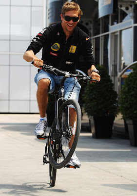 Виталий Петров вытворяет финты на велосипеде в паддоке Валенсии на Гран-при Европы 2011