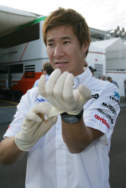 Камуи Кобаяши одевает белые резиновые перчатки на Гран-при Италии 2011