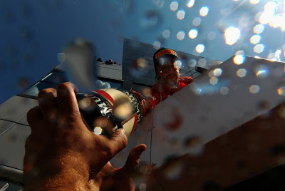 Фернандо Алонсо кидает бутылку шампанского механикам с подиума Сильверстоуна после победы на Гран-при Великобритании 2011