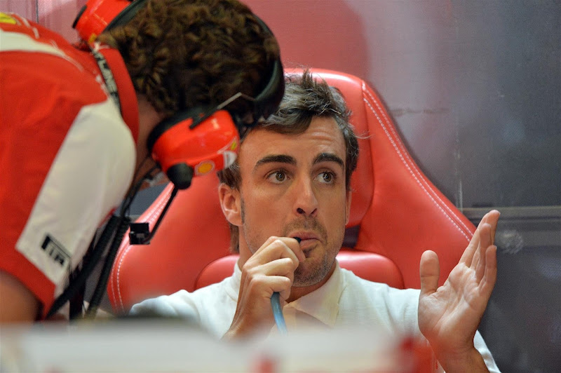 удивленный Фернандо Алонсо разводит руками в гараже Ferrari на Гран-при Венгрии 2013