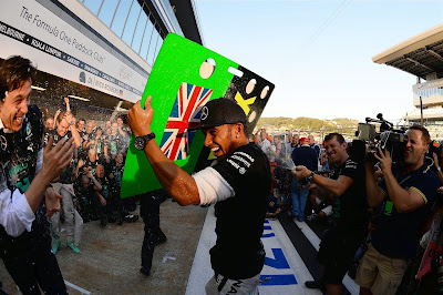 Льюис Хэмилтон спасается от шампанского на праздновании победы в кубке конструкторов на Гран-при России 2014