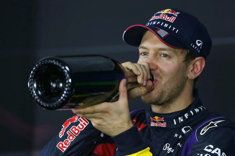 Себастьян Феттель пьет шампанское на пресс-конференции после гонки на Гран-при Индии 2013