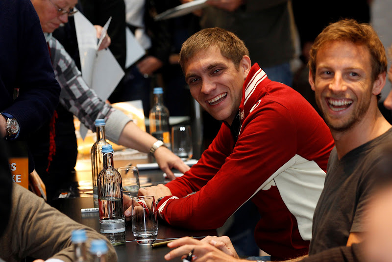 смеющиеся Виталий Петров и Дженсон Баттон на автограф-сессии Гонки чемпионов 2011