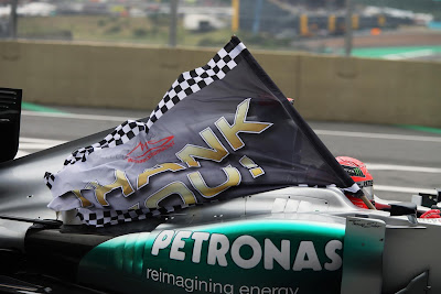 Михаэль Шумахер с флагом на трассе Интерлагос на Гран-при Бразилии 2012