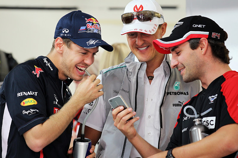 Тимо Глок показывает что-то смешное на телефоне Себастьяну Феттелю и Михаэлю Шумахеру на Гран-при Индии 2012