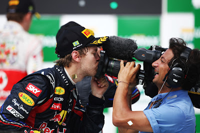 Себастьян Феттель целует телевизионную камеру на Гран-при Бразилии 2011