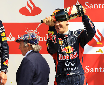 Себастьян Феттель поливает Джеки Стюарта шампанским на подиуме Гран-при Великобритании 2012