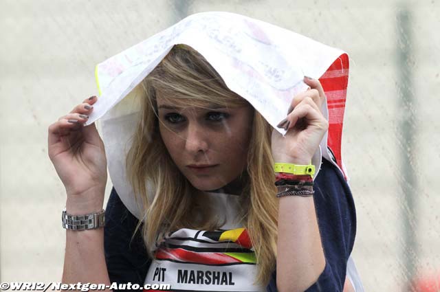 девушка маршал спасается от дождя на пит-лейне Гран-при Бельгии 2011 в Спа-Франкошам