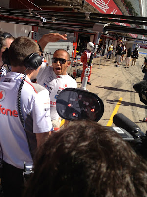 Льюис Хэмилтон показывает что-то своим механикам в пятницу на Гран-при Испании 2012