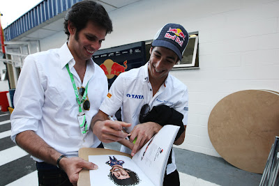 Даниэль Риккардо ставит автограф на своей карикатуре из книжки VROOOM на Гран-при Бразилии 2011