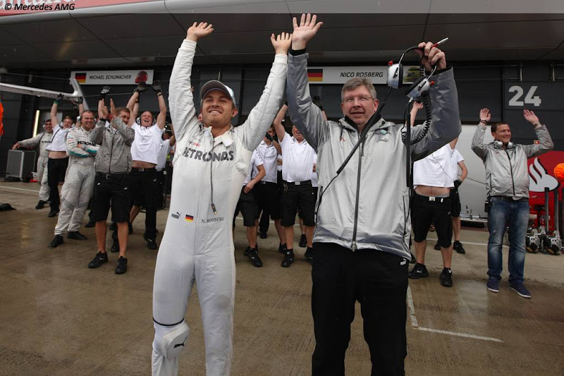 Нико Росберг и Росс Браун вместе с механиками Mercedes пускают волну во время дождевой квалификации на Гран-при Великобритании 2012