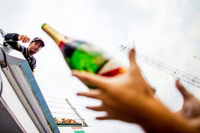 Даниэль Риккардо бросает шампанское механикам под подиумом Гран-при Венгрии 2014