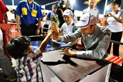 Дженсон Баттон дает пять маленькому болельщу на автограф-сессии Гран-при Бахрейна 2014