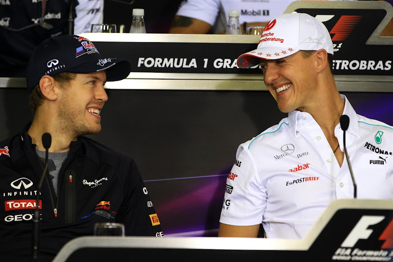 улыбающиеся Себастьян Феттель и Михаэль Шумахер на пресс-конференции в четверг на Гран-при Бразилии 2012