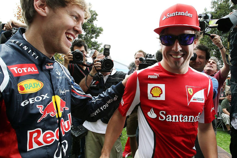 улыбающиеся Фернандо Алонсо и Себастьян Феттель встречают друг друга на Гран-при Австралии 2012