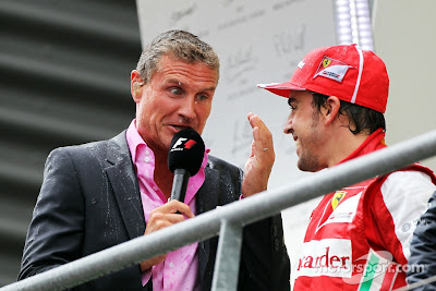 мокрый Дэвид Култхард берет интервью у Фернандо Алонсо на подиуме Гран-при Бельгии 2013