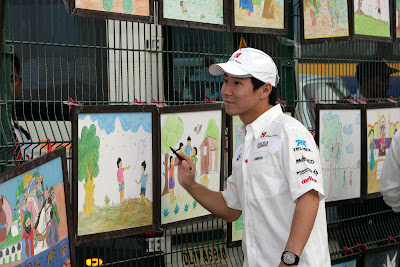 Камуи Кобаяши подписывает картины на Гран-при Индии 2011