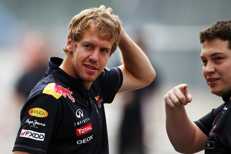механик показывает пальцем куда-то и Себастьян Феттель чешет голову на Гран-при Италии 2011 в Монце