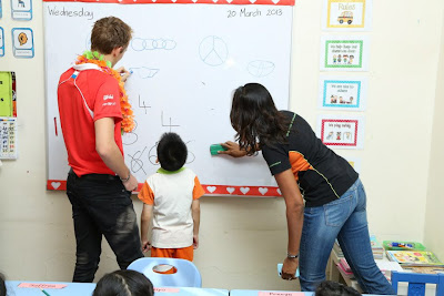 Макс Чилтон рисует на доске в малайзийской школе Taarana на Гран-при Малайзии 2013