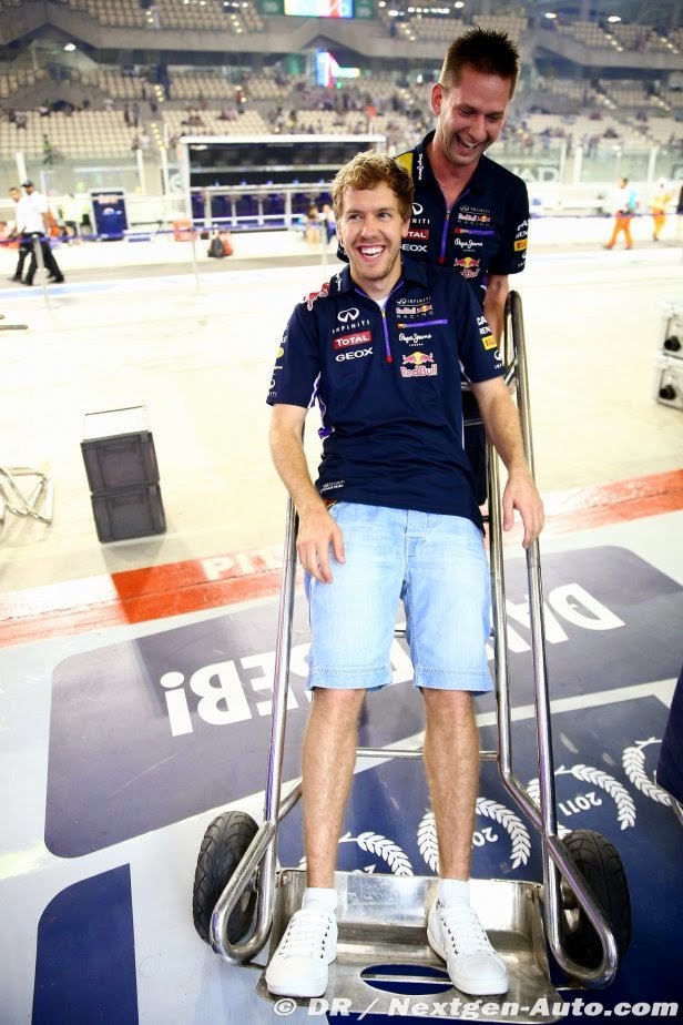 механик Red Bull катает Себастьяна Феттеля на тележке на Гран-при Абу-Даби 2014