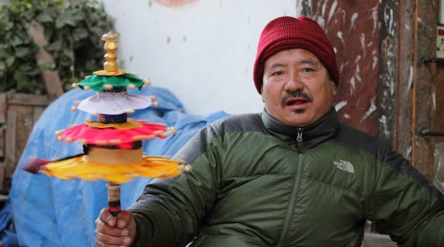 Local Trongsa Man with a colorful prayer wheel