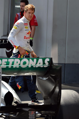Себастьян Феттель посматривает на болид Mercedes после квалификации на Гран-при Германии 2013