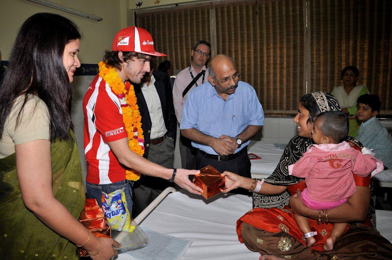 Фернандо Алонсо передает подарок индийской семье на Гран-при Индии 2011