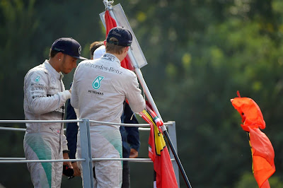 Нико Росберг ставит автограф на флаге болельщика на подиуме Монцы на Гран-при Италии 2014