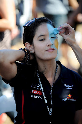 болельщица Red Bull наносит боевую раскраску на лицо на Гран-при Австралии 2012