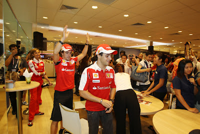 Фернандо Алонсо с поднятыми руками позади Фелипе Массы на Гран-при Сингапура 2010