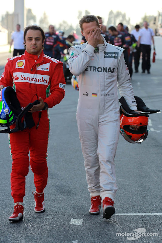 Фелипе Масса и фэйспалмящий Михаэль Шумахер идут по пит-лейну на предсезонных тестах 2012 в Барселоне 23 февраля 2012
