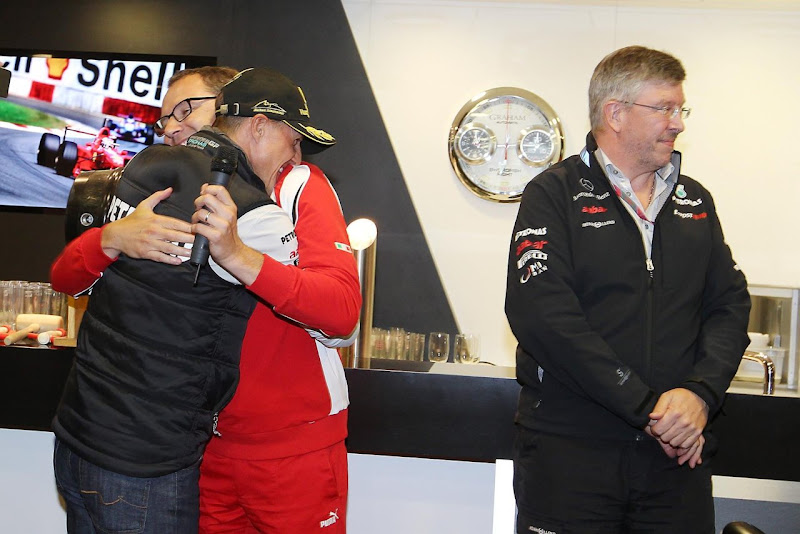 Стефано Доменикали и Михаэль Шумахер обнимаются, Росс Браун стоит отвернувшись на главной вечеринке Гран-при Бельгии 2011