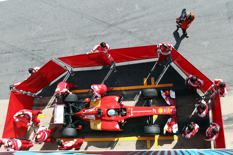 механики прячут болид Ferrari от фотокамер на предсезонных тестах в Барселоне 3 марта 2013