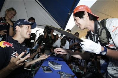 Себастьян Феттель и болельщик McLaren смеются на автограф-сессии Гран-при Японии 2011