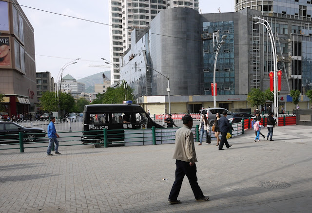 Police van and policeman holding a large gun in Xining, China