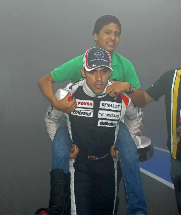 Пастор Мальдонадо уносит своего брата от пожара на Гран-при Испании 2012