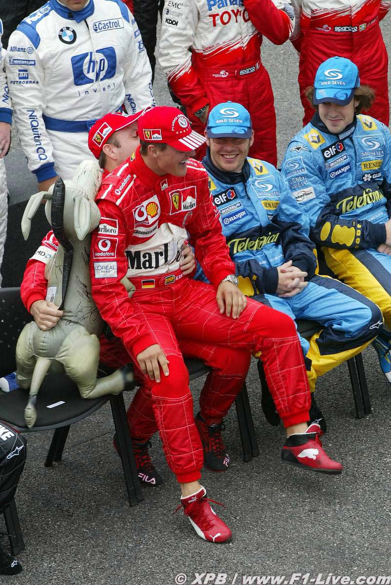 Михаэль Шумахер садится на колени Рубенса Баррикелло на Гран-при Бразилии 2004