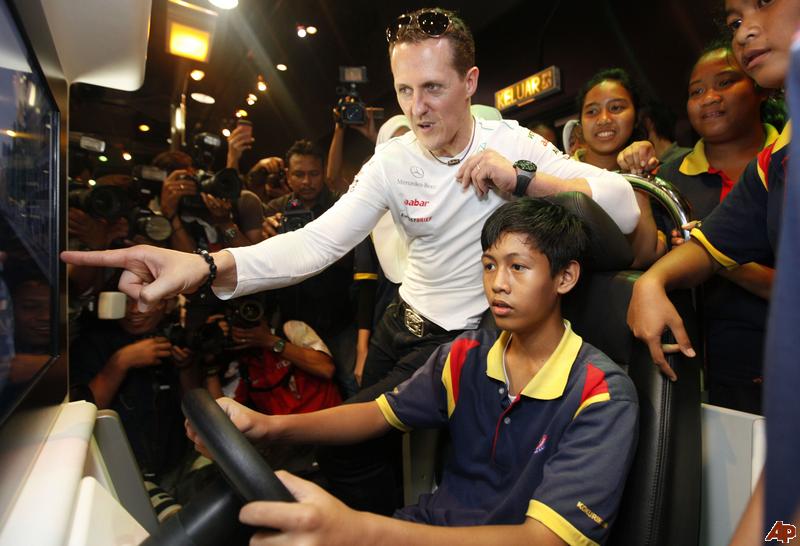 Михаэль Шумахер дает советы мальчику на гоночном симуляторе на Гран-при Малайзии 2012