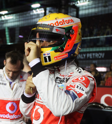 Льюис Хэмилтон протирает визор пальцем перед стартом гонки на Гран-при Сингапура 2011