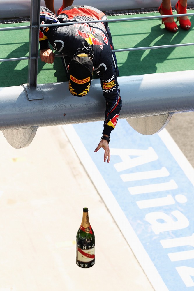 Себастьян Феттель бросает бутылку шампанского с подиума на Гран-при Италии 2011