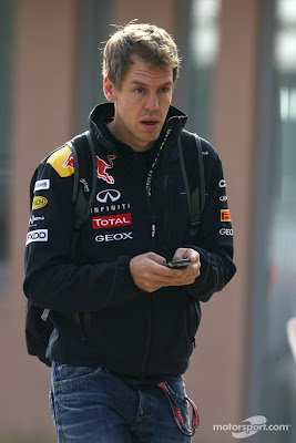 Себастьян Феттель с удивленными глазами и телефоном в руках на Гран-при Кореи 2011