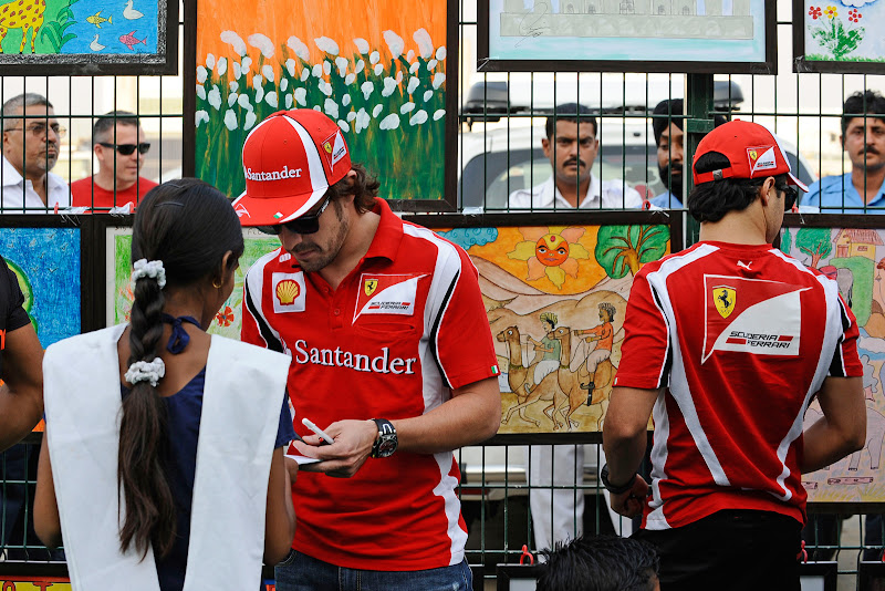 Фернандо Алонсо и Фелипе Масса подписывают рисунки индийских школьников на Гран-при Индии 2011